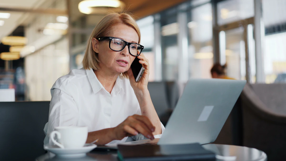 A founder on the phone at her laptop with a coffee beside her